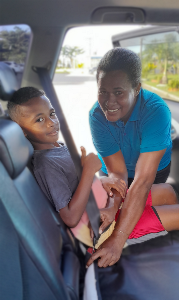 LTA staff Asilika Marama secures her son Tukana in the backseat of the car. LTA and police are urging drivers and passengers to buckle up for their safety. Image LTA LTA staff Asilika Marama secures her son Tukana in the backseat of the car. LTA and police are urging drivers and passengers to buckle up for their safety. Image LTA