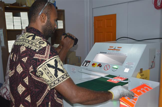 LTA staff operate shredder machine to destroy old number plate.